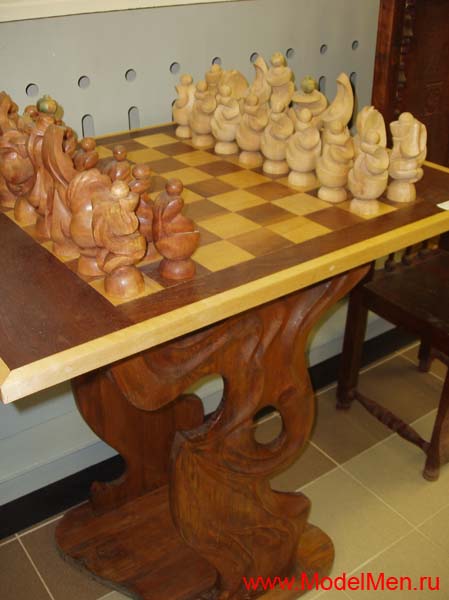 резной шахматный стол и шахматы